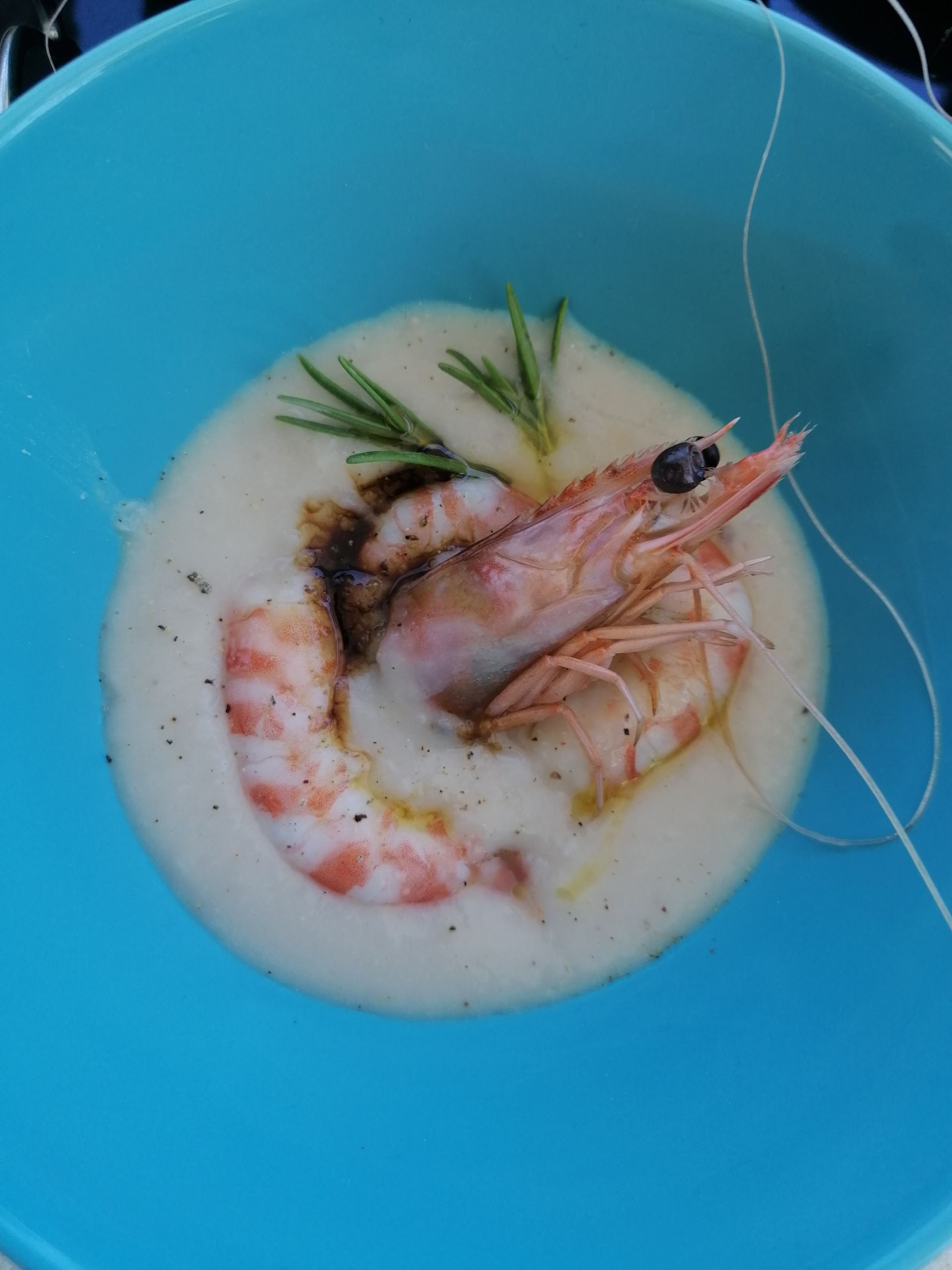 Un primo piano di una ciotola di zuppa con gamberetti dentro
