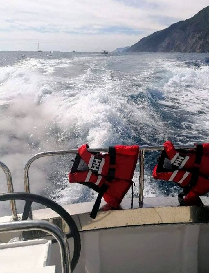 Una barca sta attraversando l'oceano con i giubbotti di salvataggio sul lato