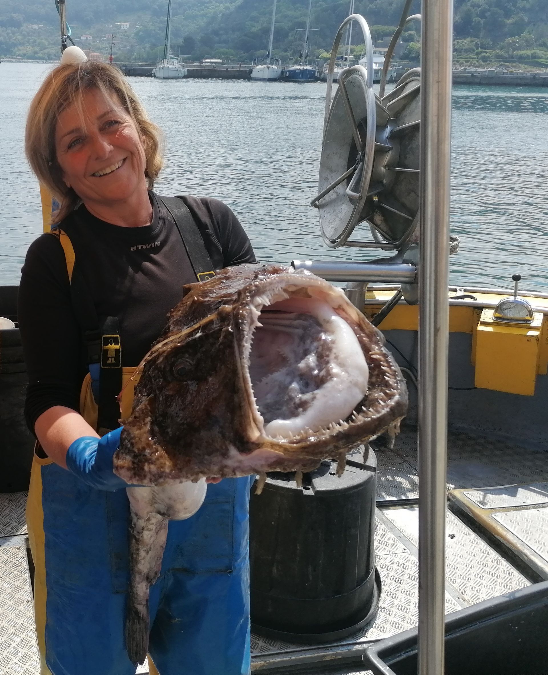 Una donna tiene in mano un grosso pesce