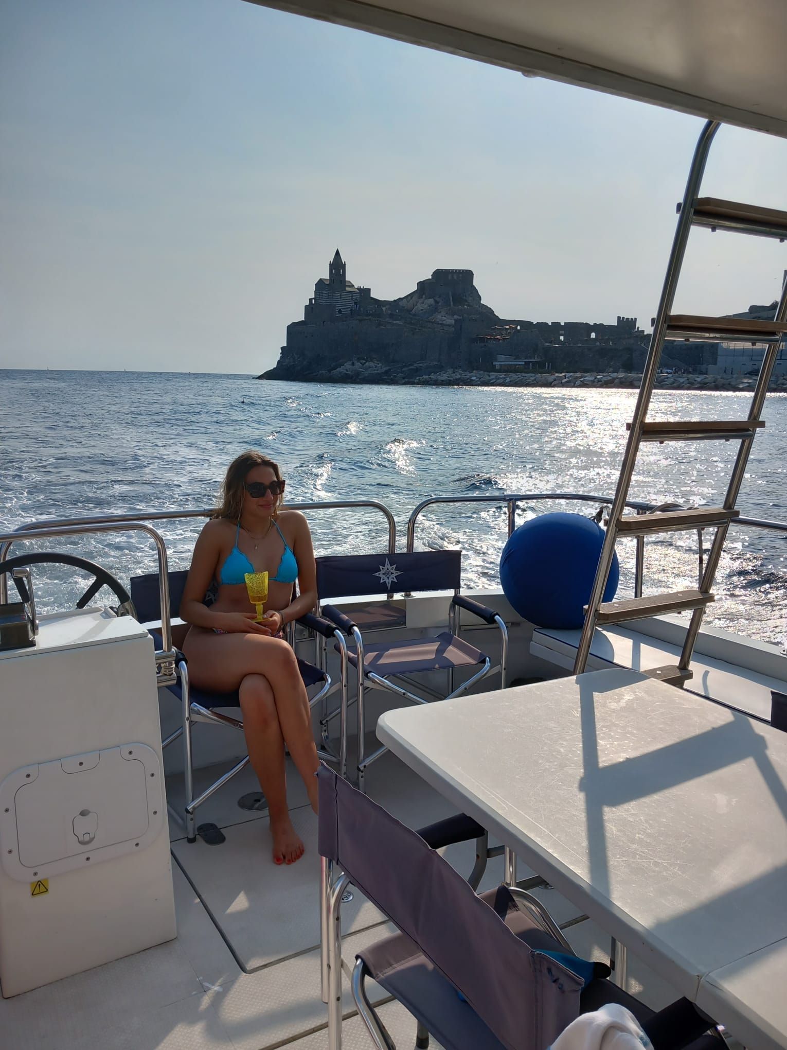 Una donna in bikini è seduta su una barca nell'oceano.