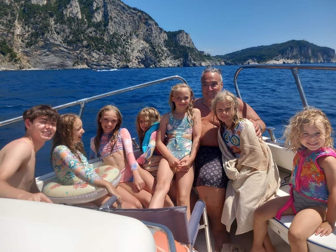 Un gruppo di bambini è seduto su una barca nell'oceano.