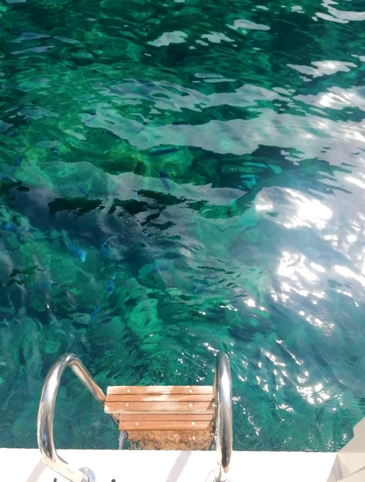 Una scala di legno che conduce a uno specchio d'acqua