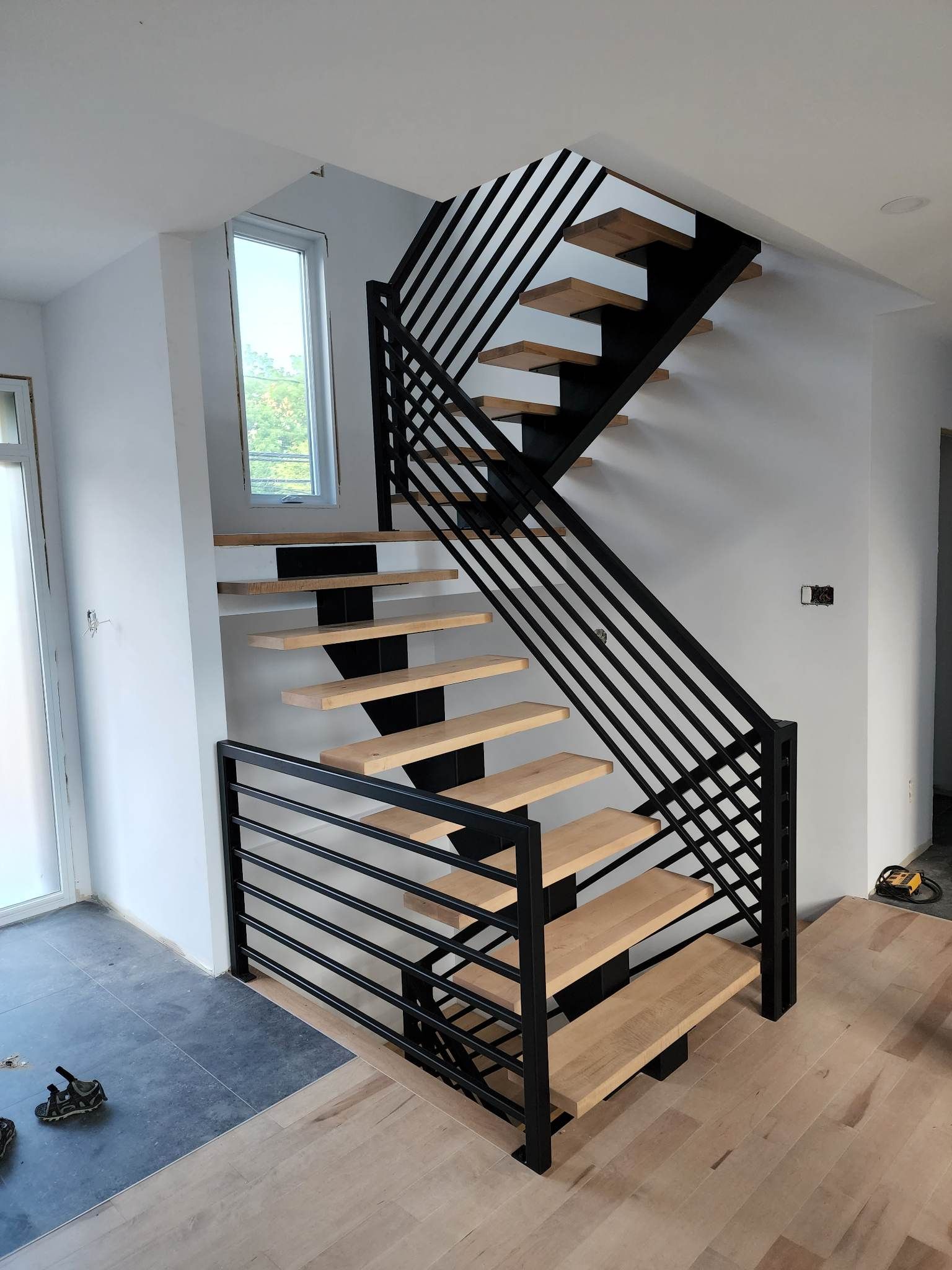 Un escalier en bois avec une rampe en métal dans une pièce.