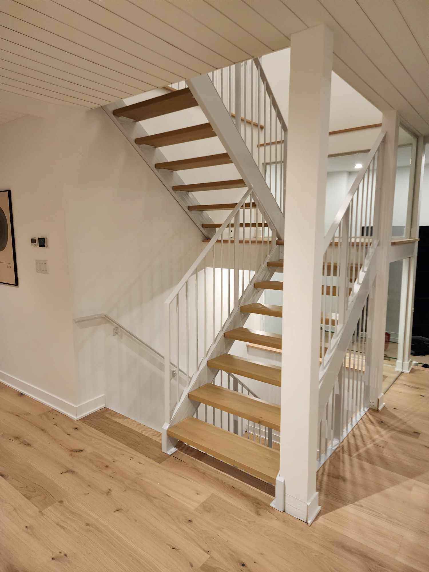A staircase with wooden steps and a white railing in a house.