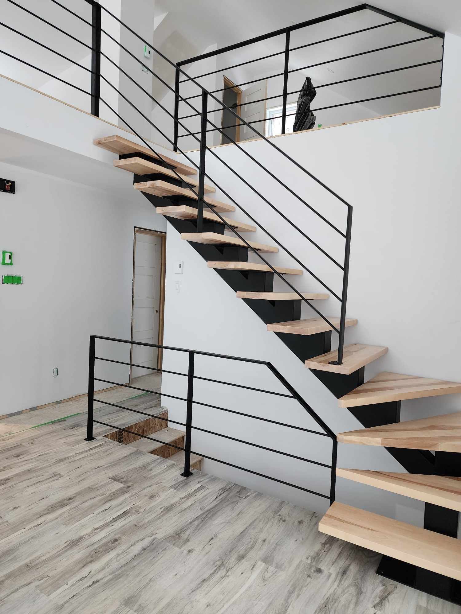 A staircase with wooden steps and a black railing