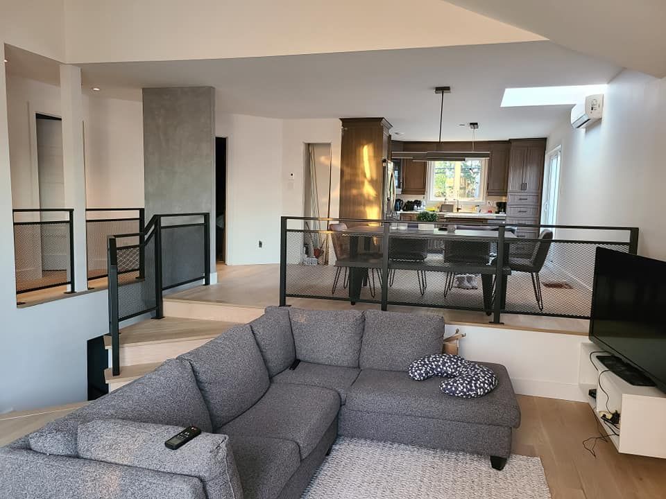 Un salon avec un canapé sectionnel et une télévision à écran plat