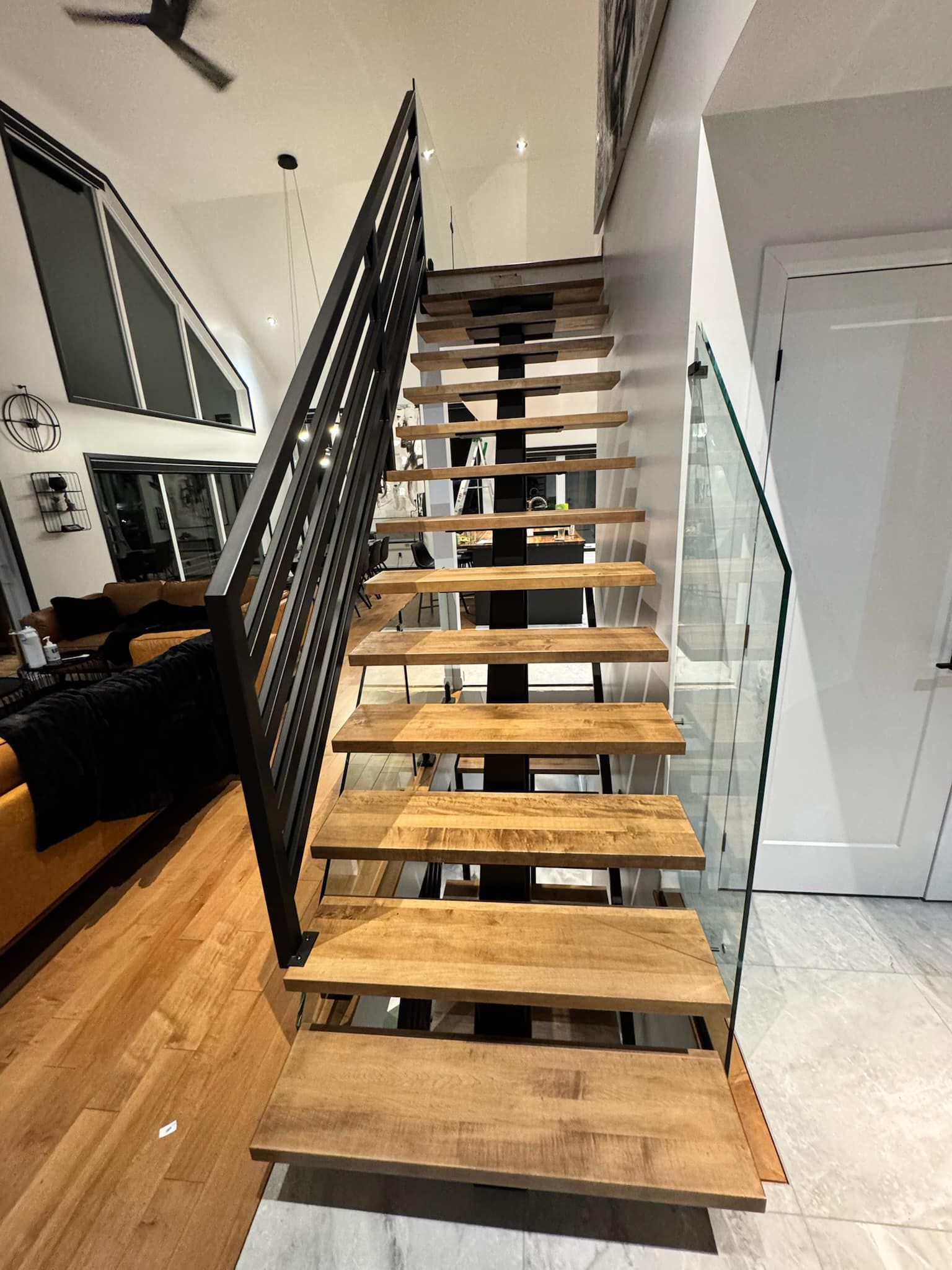 Un escalier en bois avec une rampe en métal dans un salon.