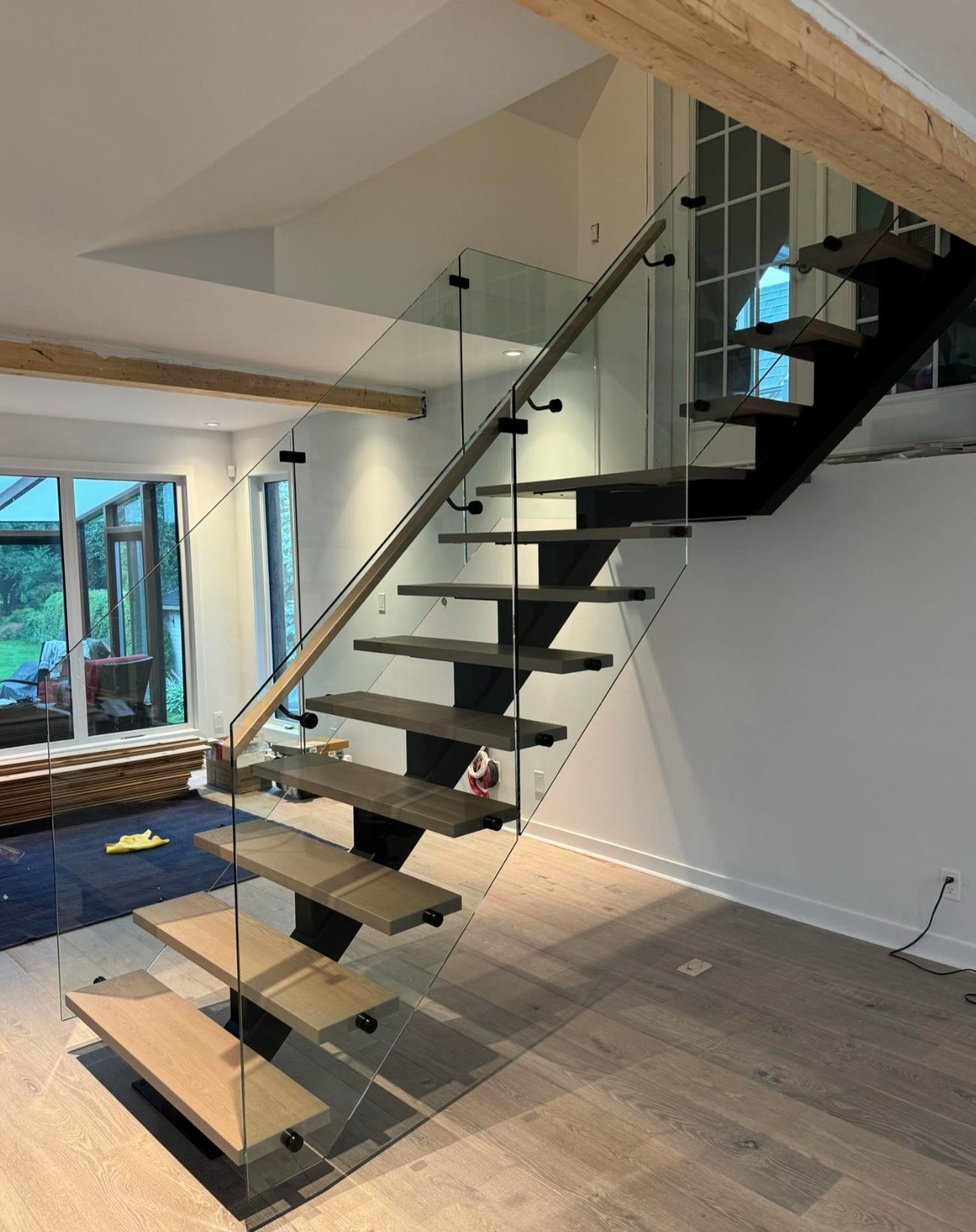 Un escalier avec une rampe en verre dans un salon.