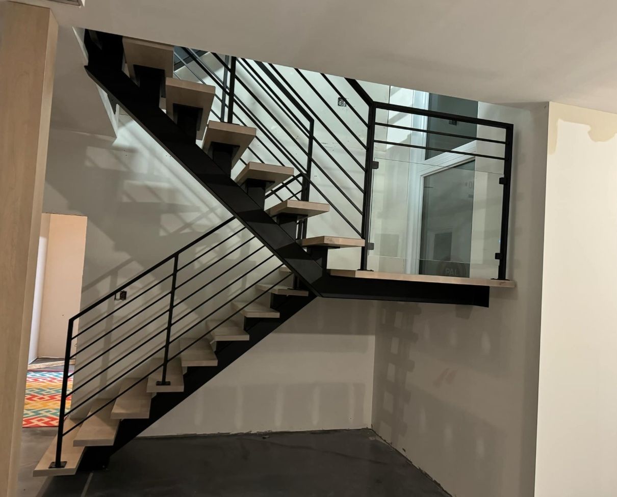 Un escalier avec une rampe noire et des marches en bois