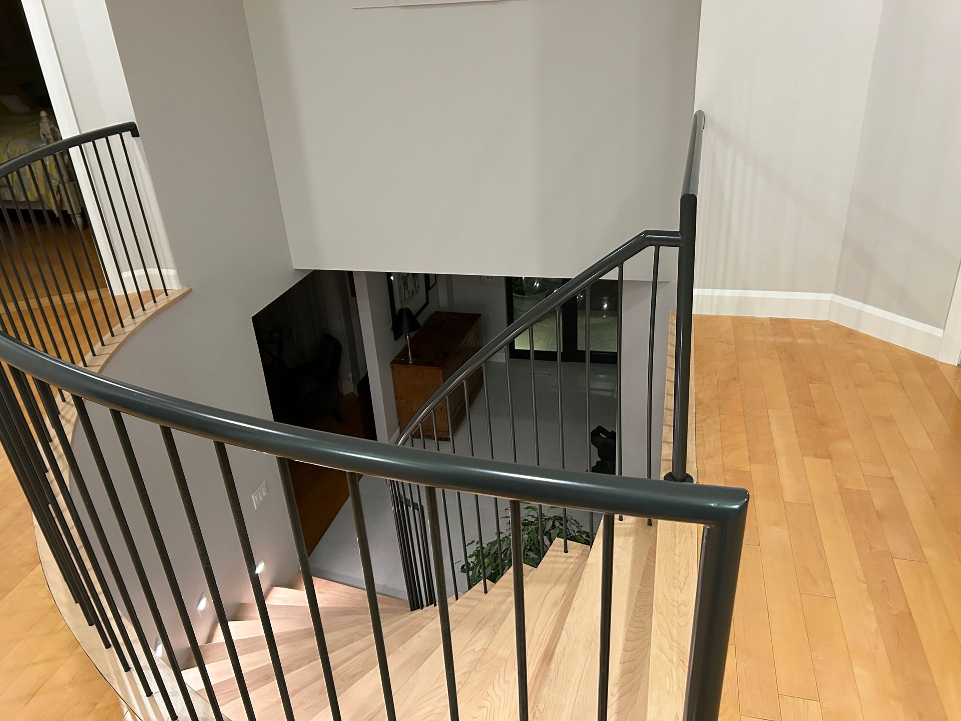 Un escalier en bois avec une rampe noire dans une maison.