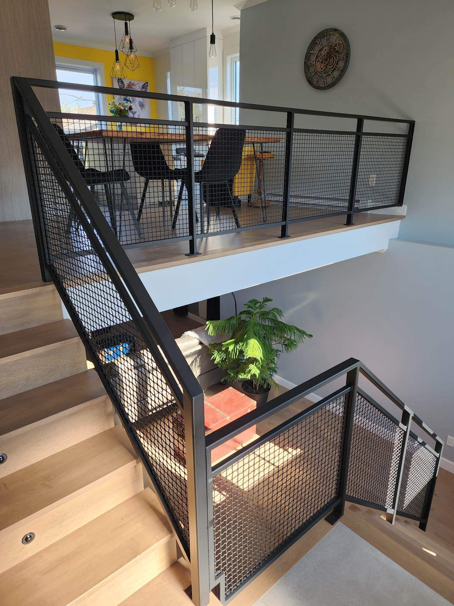 Un escalier avec une rampe en métal menant à un deuxième étage dans une maison.