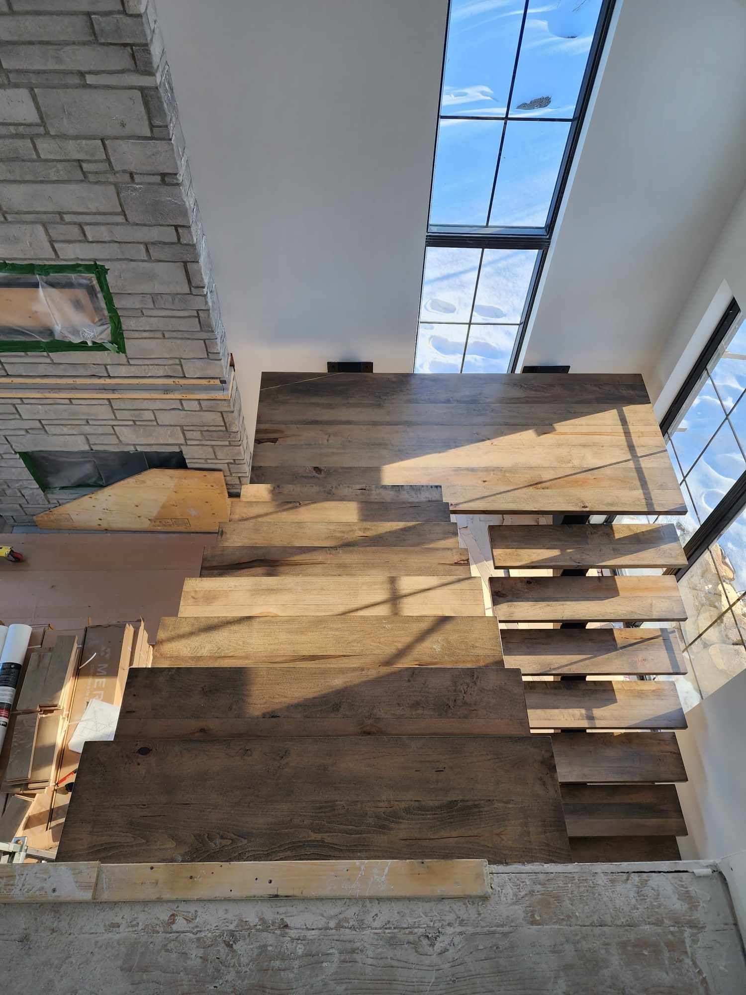 A wooden staircase is being built in a house.