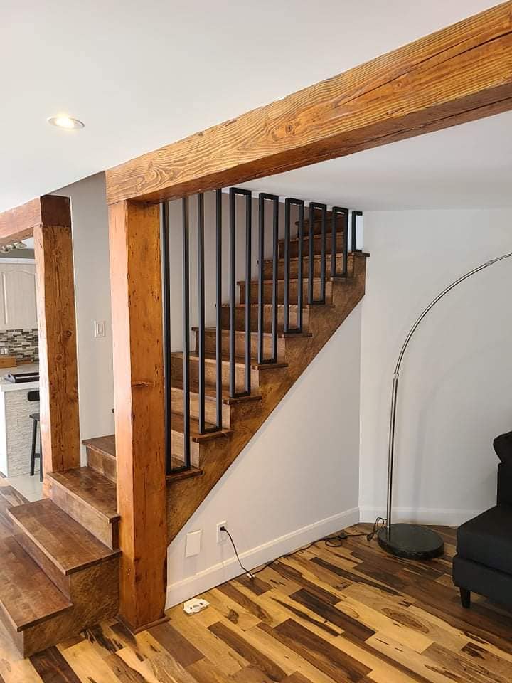 A wooden staircase with a metal railing in a living room.