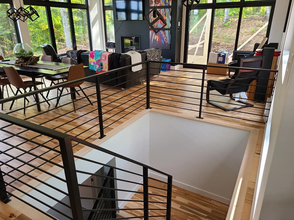 A view of a living room from the second floor of a house.