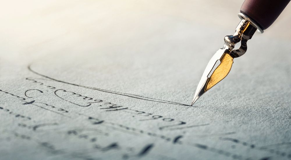 A fountain pen is writing on a piece of paper.