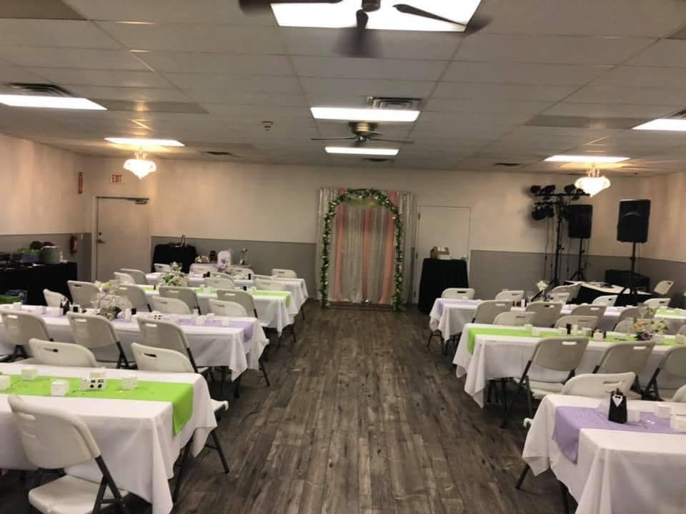 A large room with tables and chairs set up for a wedding reception.