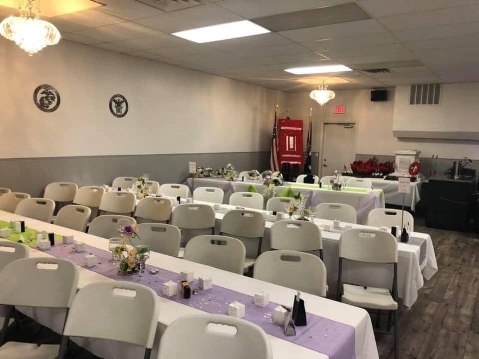 A large room with tables and chairs set up for a party.