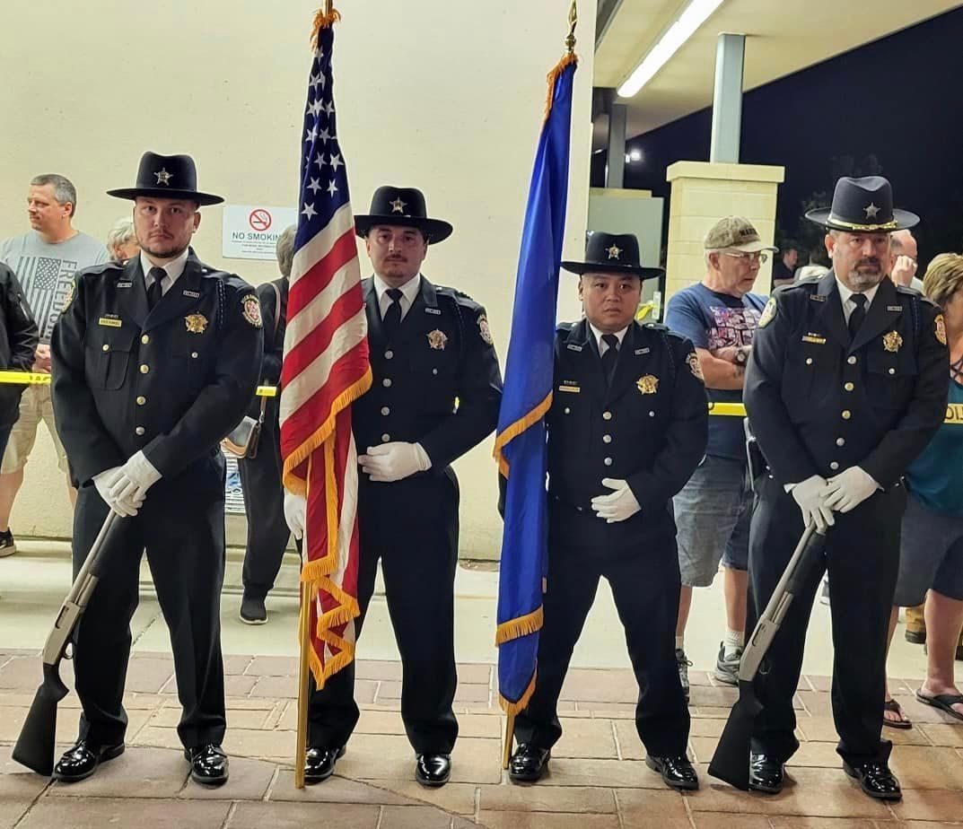 A group of police officers standing next to each other holding flags