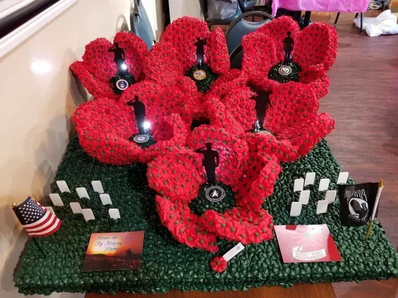 A bunch of red flowers are sitting on top of a table.