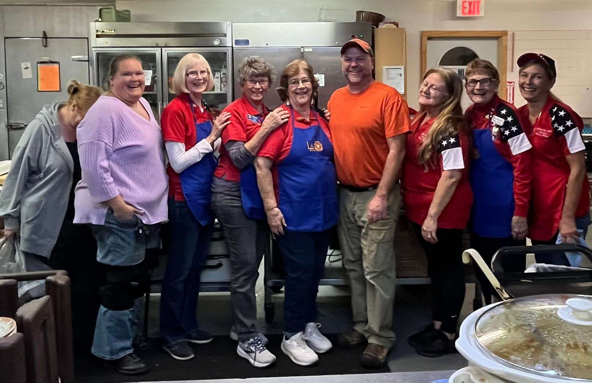 A group of people are posing for a picture in a kitchen.