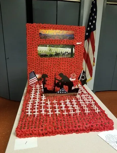 A model of a soldier kneeling in front of an american flag