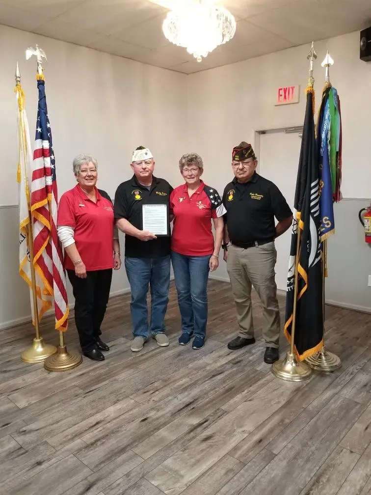 A group of people are standing in a room with flags.