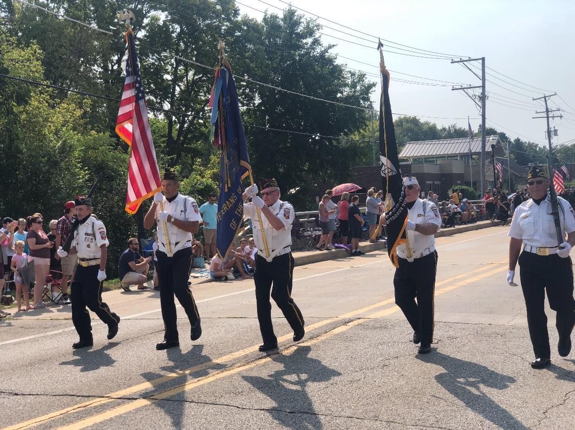 A group of men are marching down a street holding flags.
