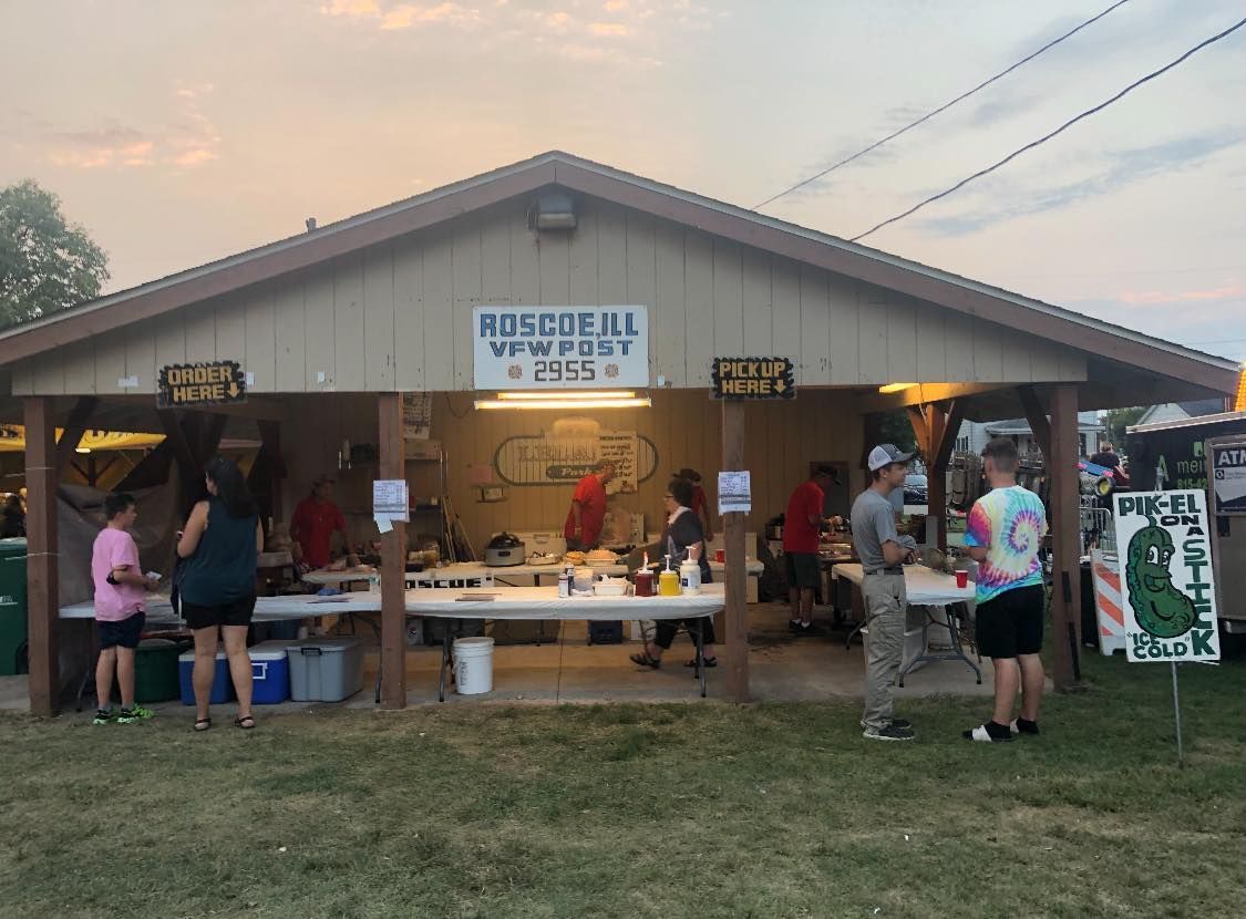 A group of people are standing in front of a pavilion.