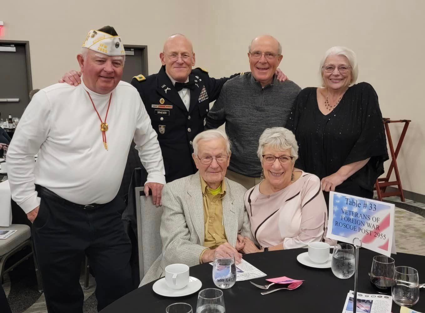 A group of people are posing for a picture at a table.