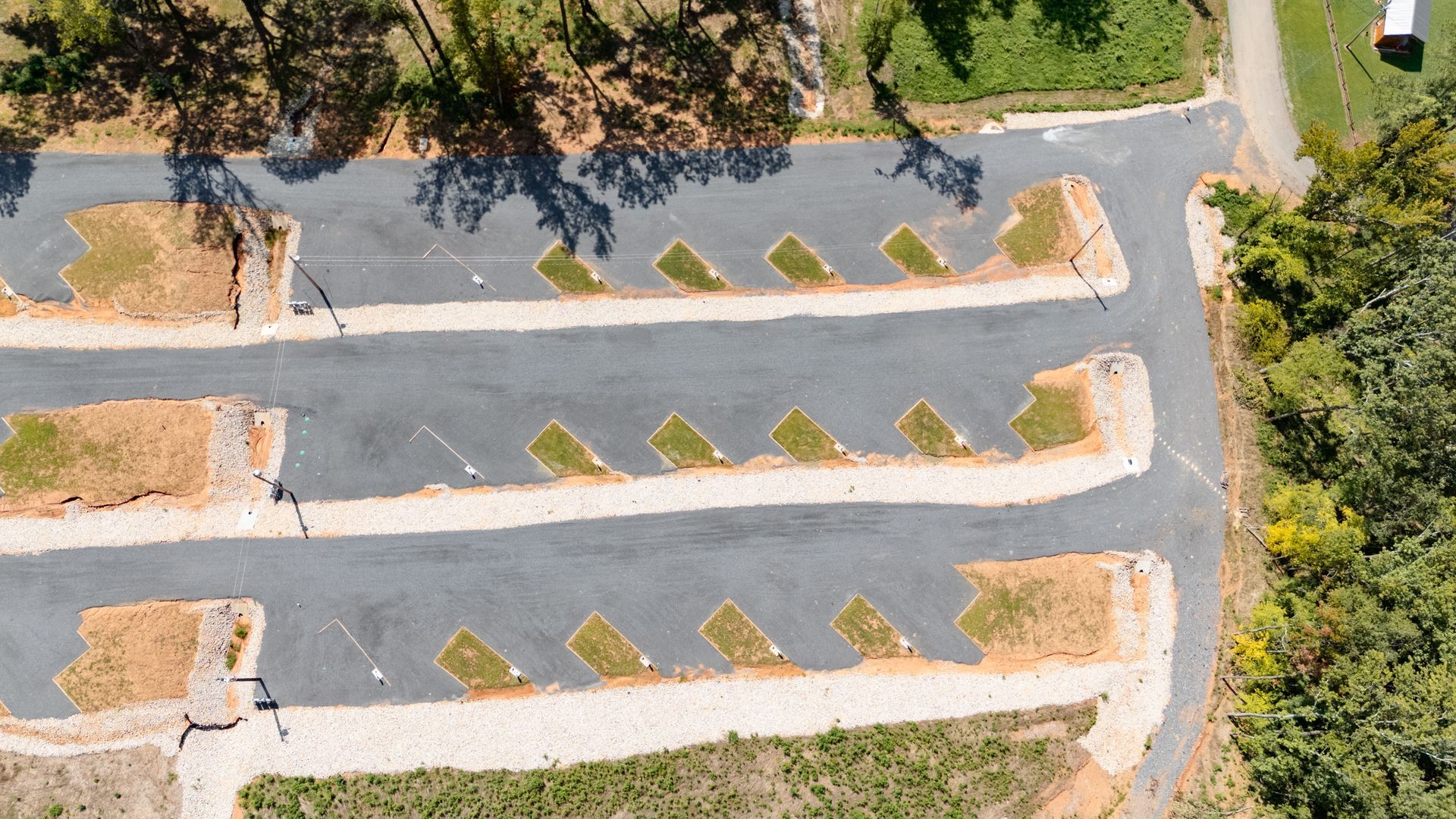An aerial view of a parking lot with trees in the background