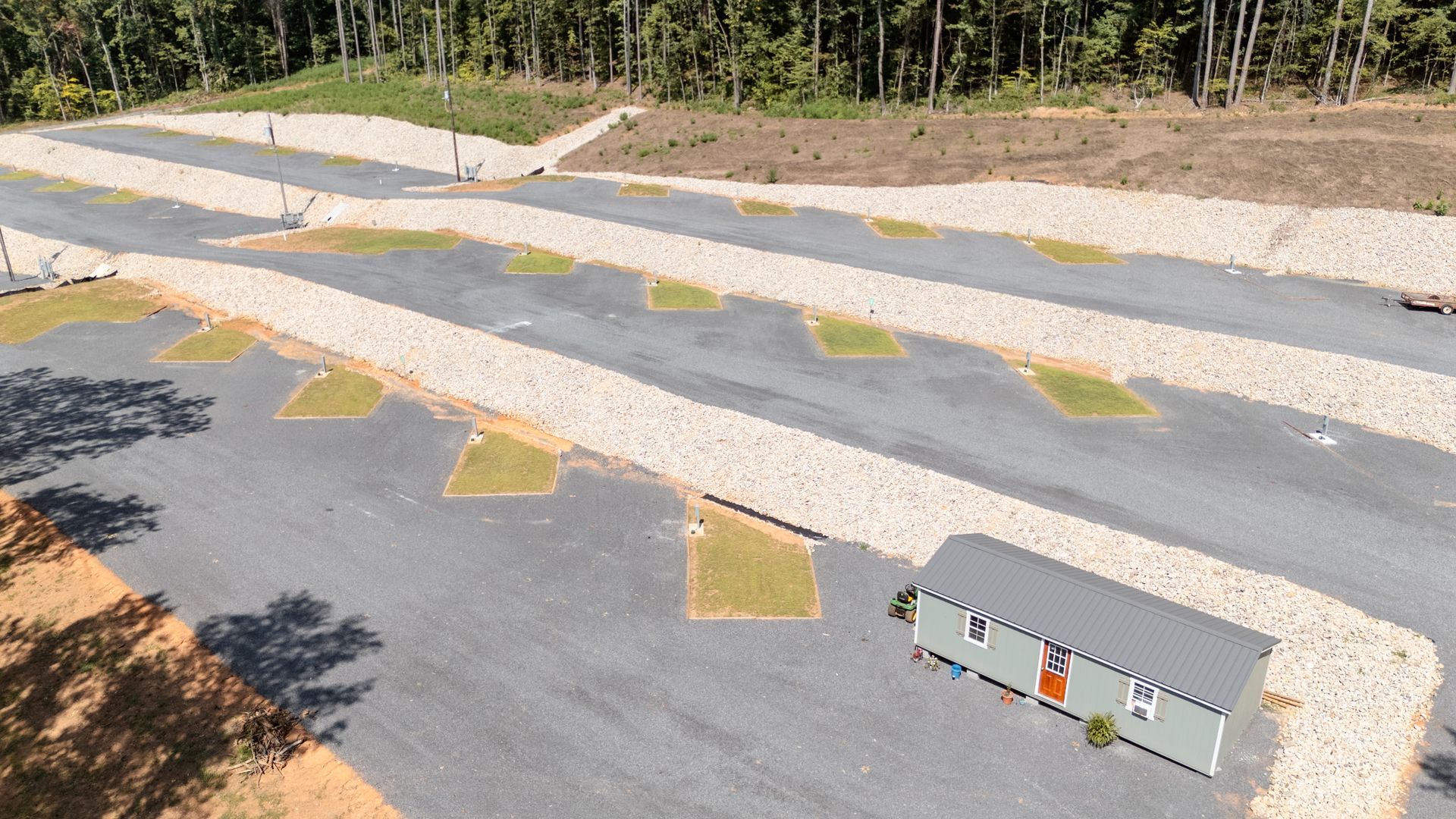An aerial view of a parking lot with a small building in the middle.