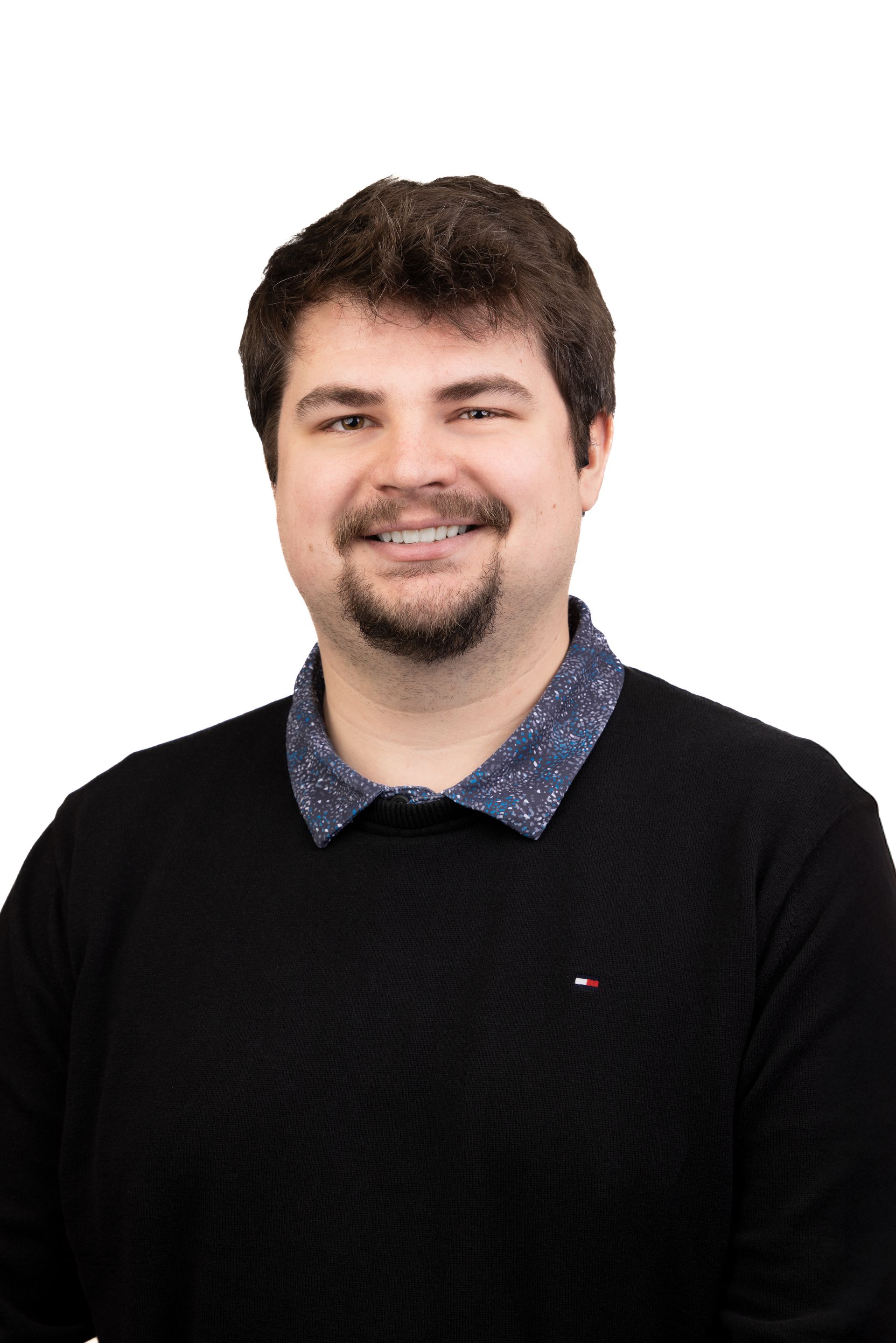 A man with a beard and glasses is smiling for the camera.