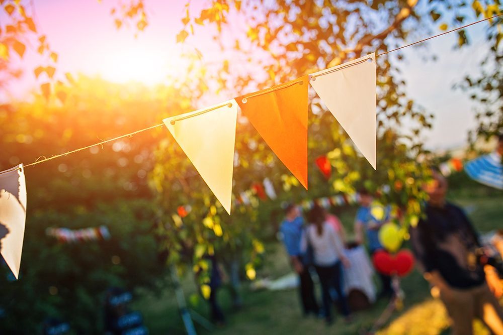 A bunch of flags are hanging from a string at a party.