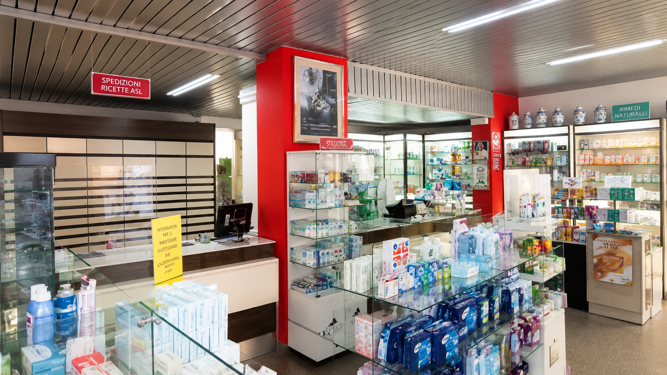 Area casse di un minimarket con bevande, snack e vetrine in vetro in un interno luminoso