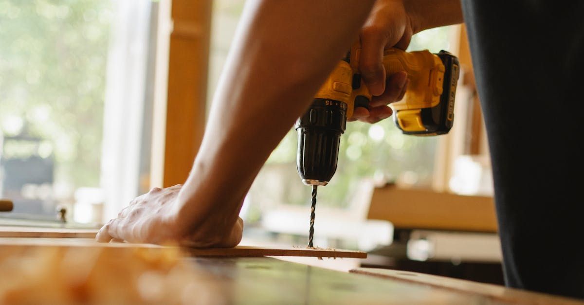 A person is using a drill to drill a hole in a piece of wood.