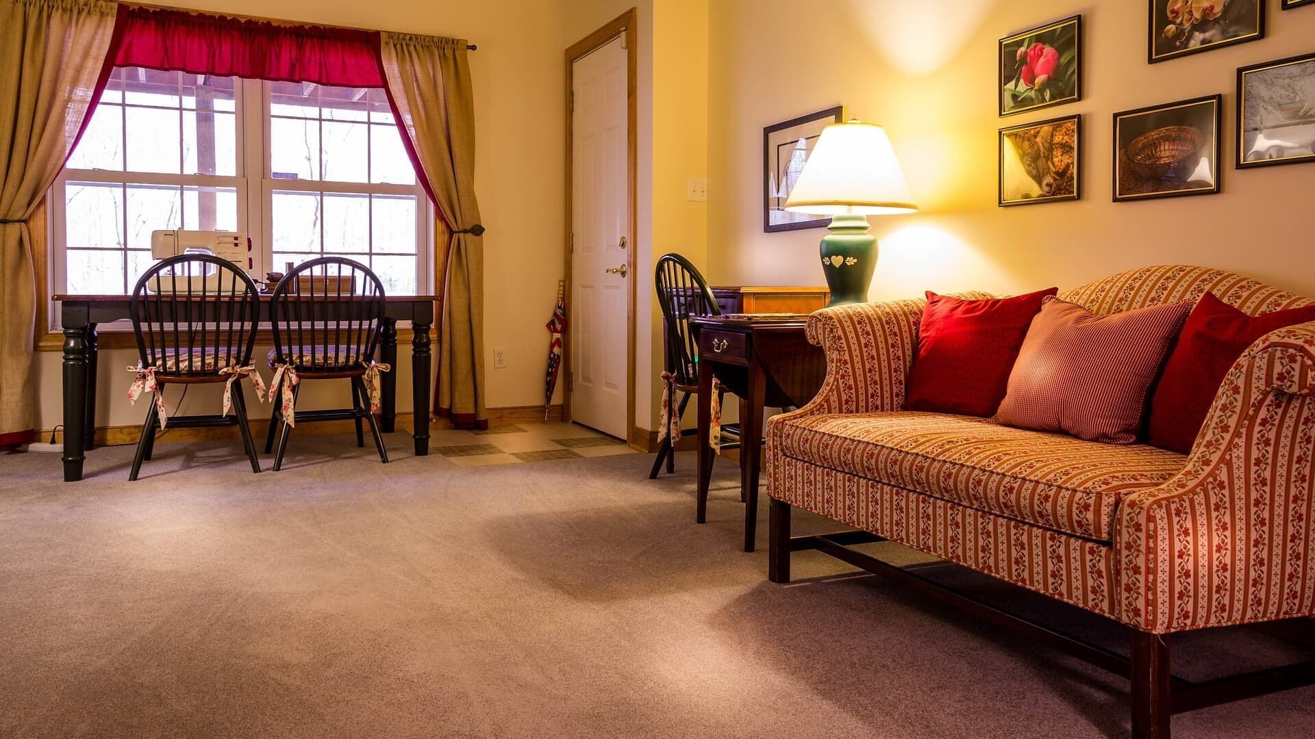 Cozy living area with a window, sofa, table, chairs, and decorative wall art.