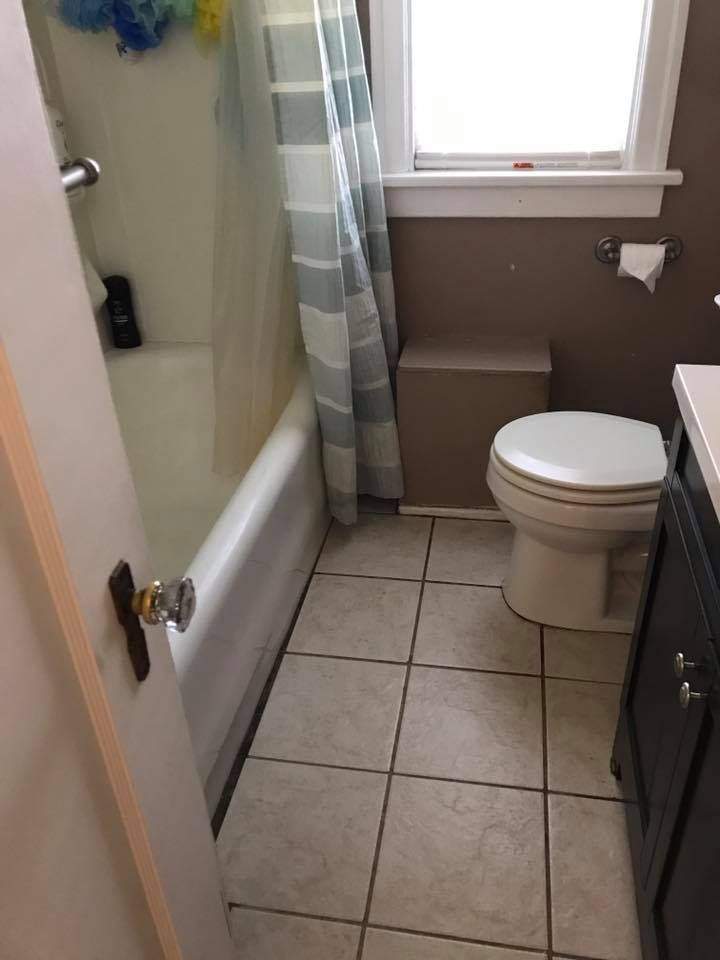 Bathroom with bathtub, toilet, and vanity; beige and white color scheme.