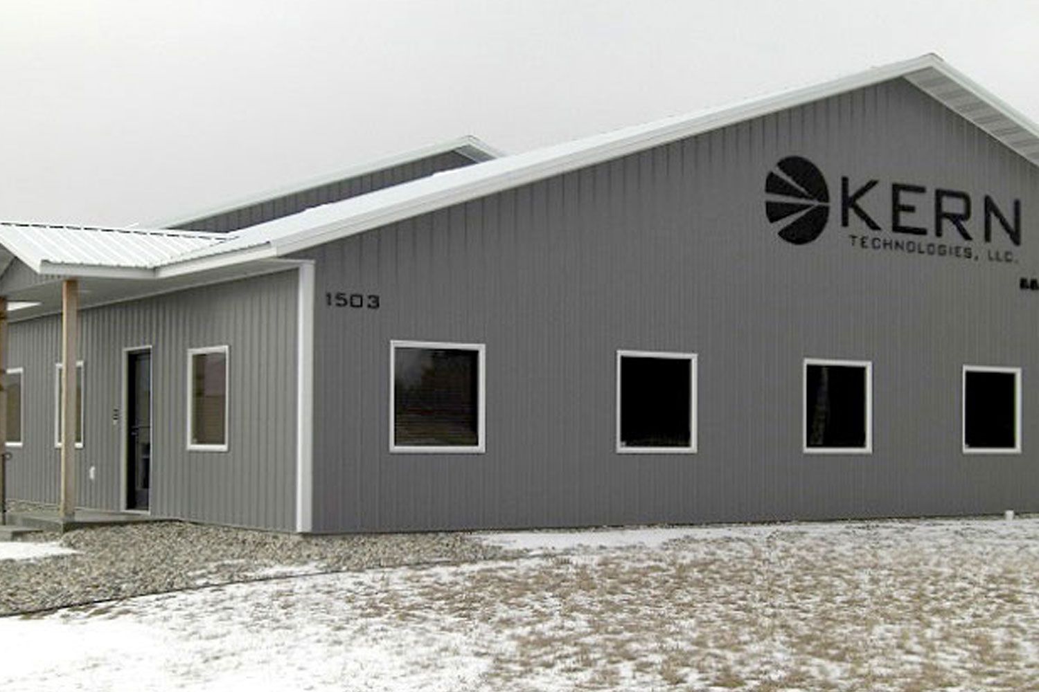 Gray metal building with Kern Technologies logo; snow on ground.