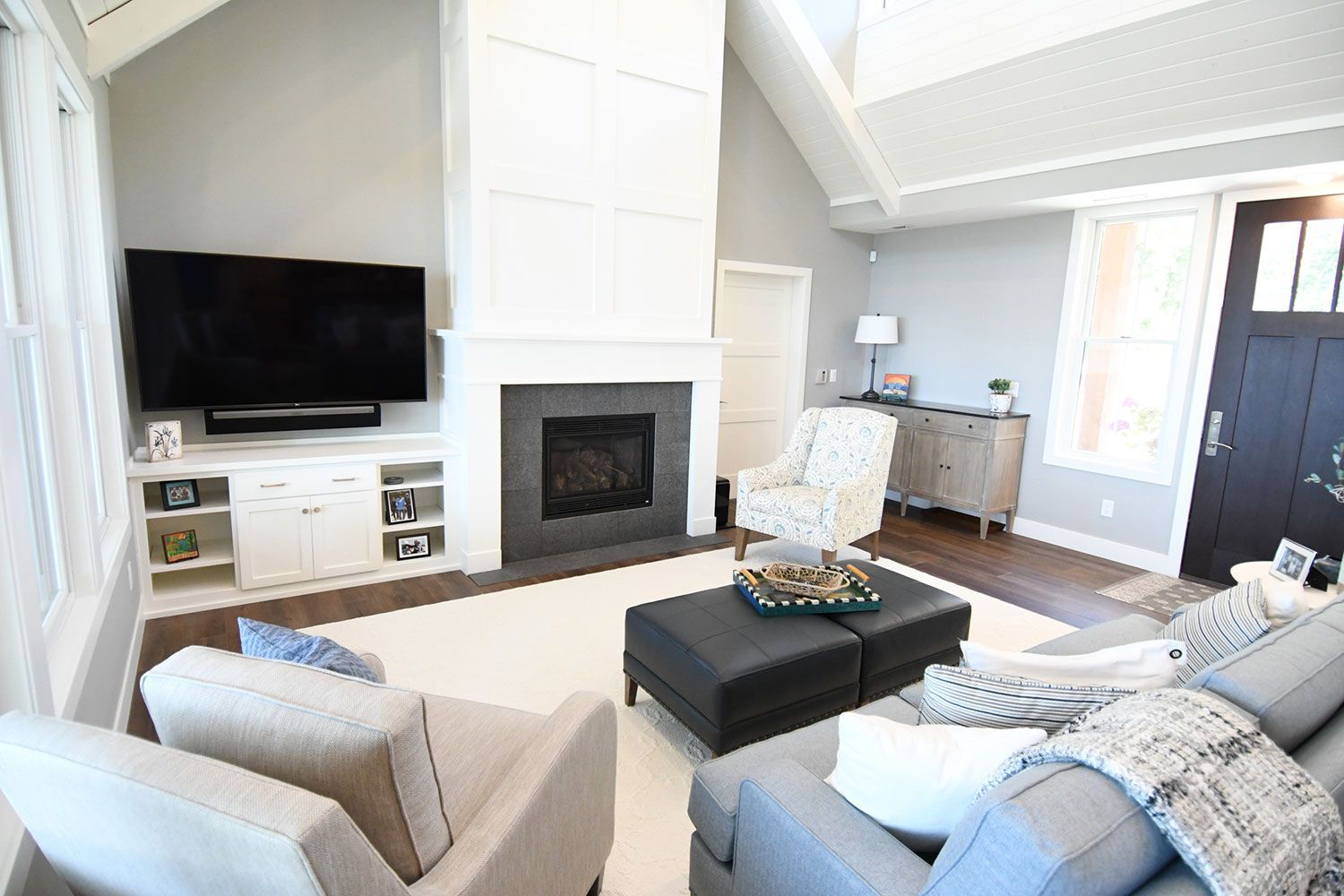Living room with fireplace, TV, seating, and light gray walls.