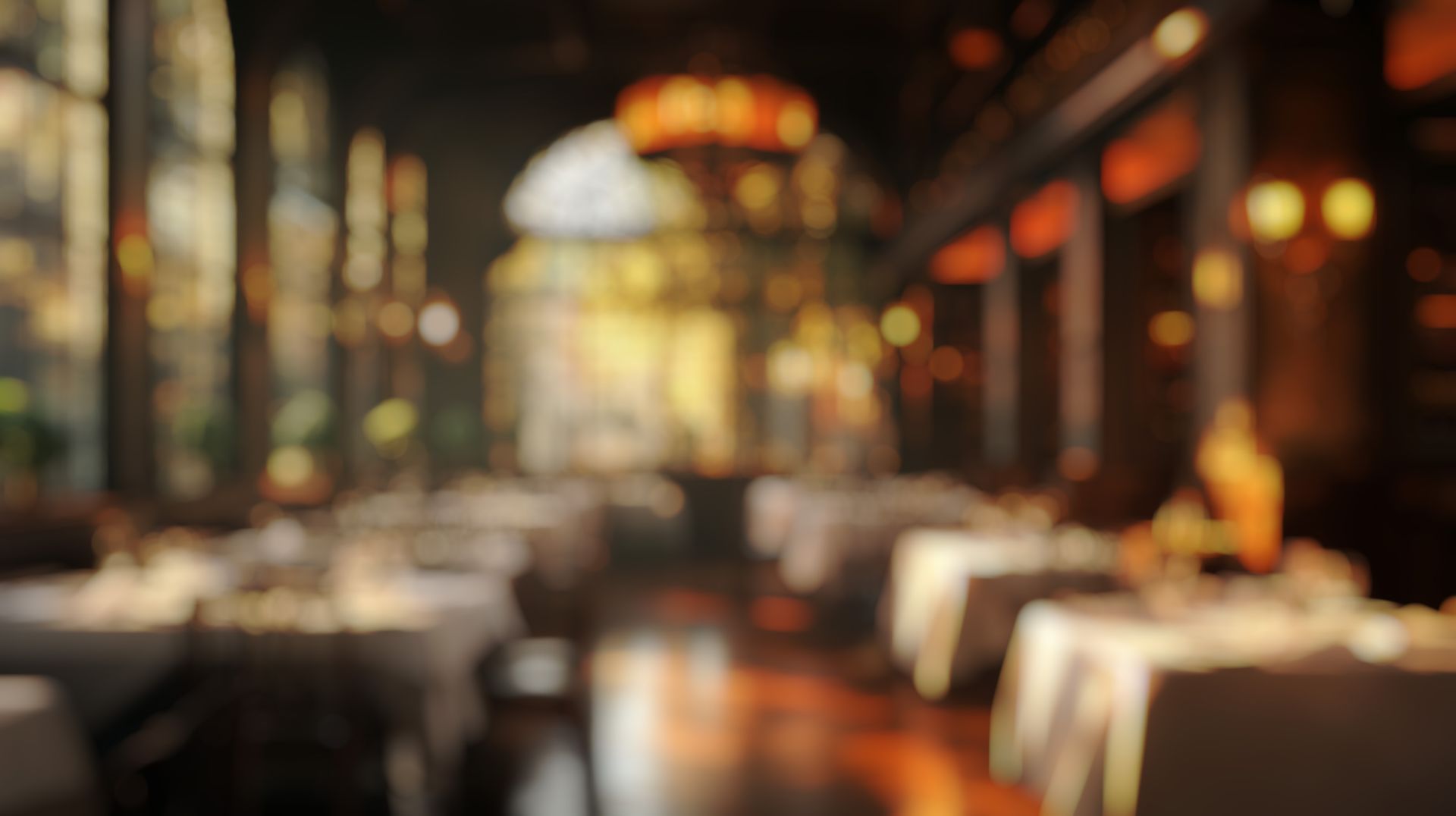 A blurry picture of a restaurant with tables and chairs.