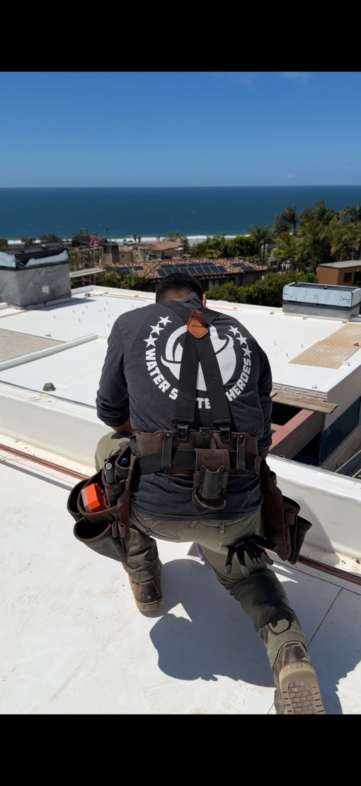 Technician adjusting an outdoor electrical control panel beside a modern house.