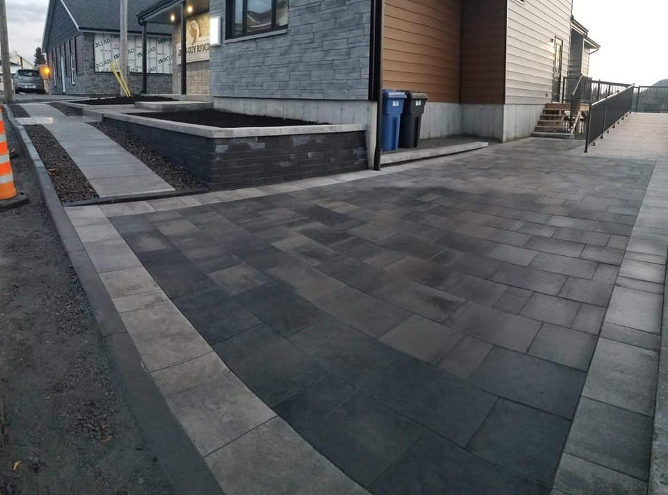 Une allée en briques est en cours de construction devant une maison