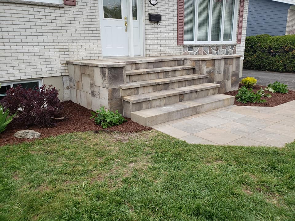 Il y a des escaliers qui mènent à la porte d'entrée d'une maison.