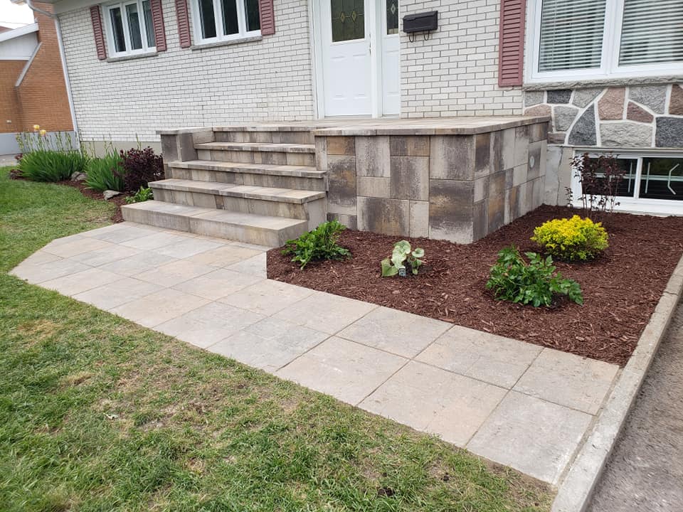 Une maison avec des escaliers et une passerelle devant elle.