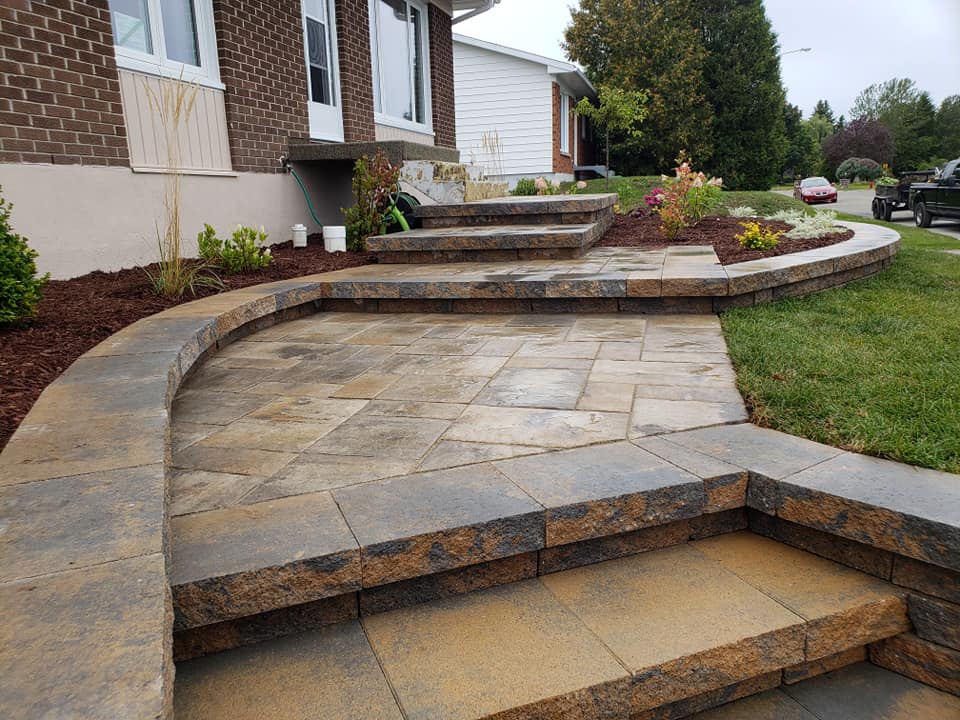 Une allée en pierre avec des marches menant à une maison.