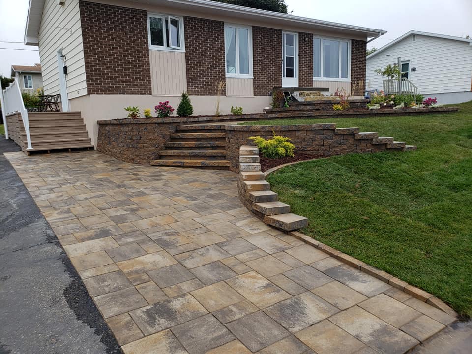 Une maison avec une allée et des escaliers devant elle.