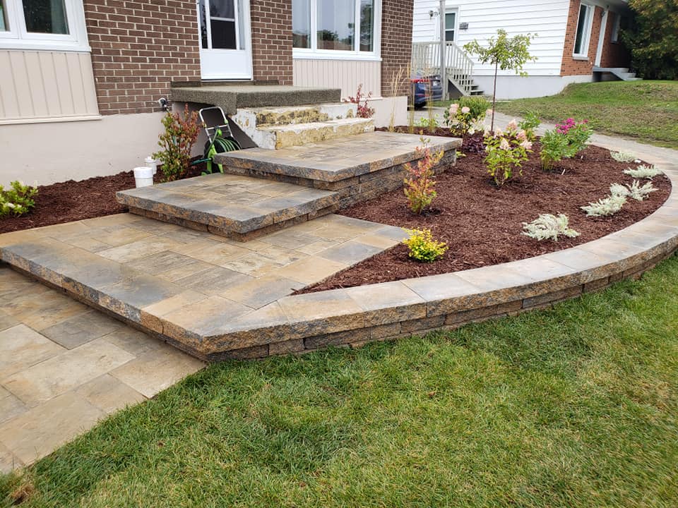 Une maison en briques avec un patio et des marches devant.