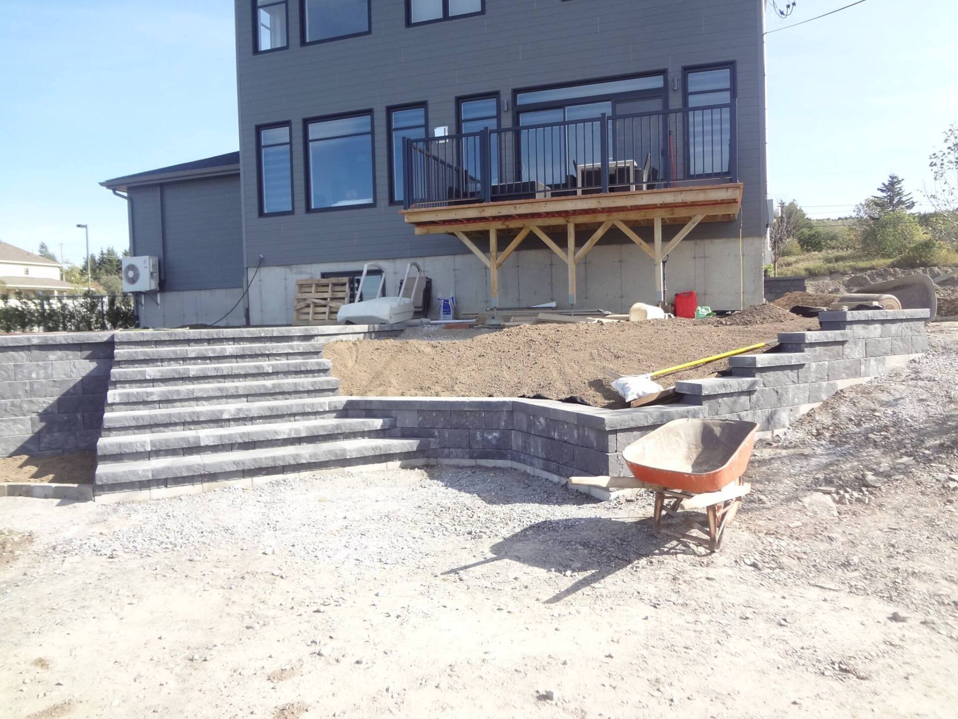 Une brouette est assise devant une grande maison