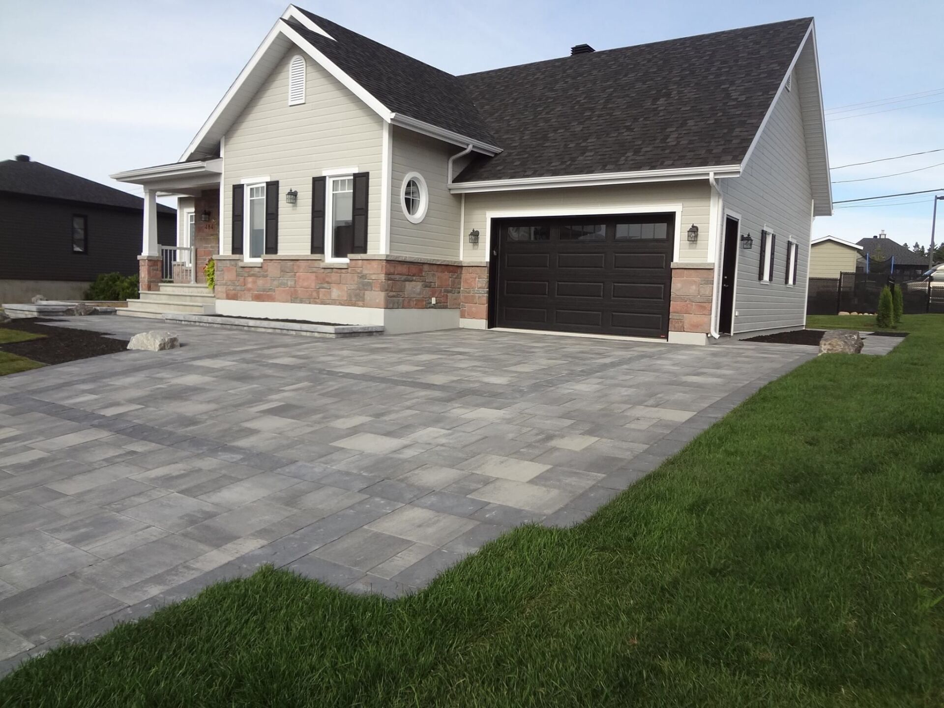 Une maison blanche avec une porte de garage noire