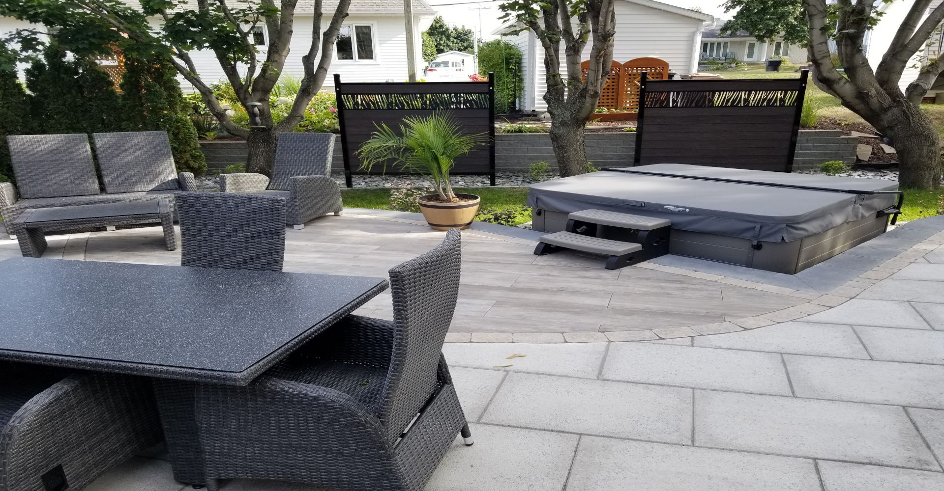 Un patio avec une table et des chaises et un bain à remous